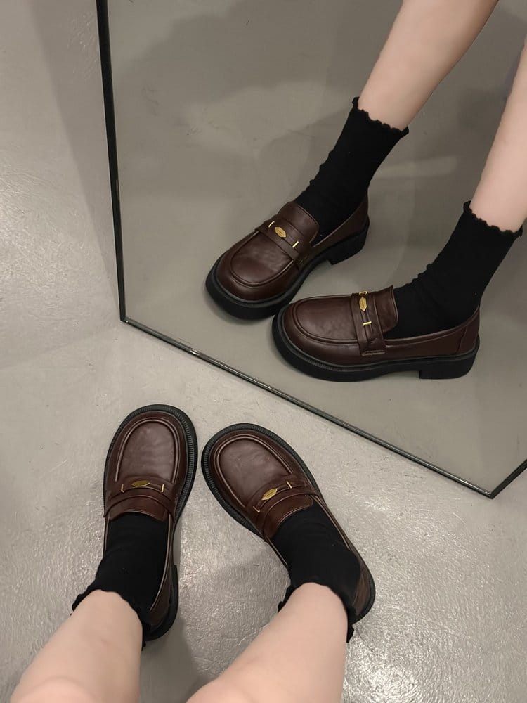 Brown leather loafers with gold tone metal buckle detail and chunky sole.