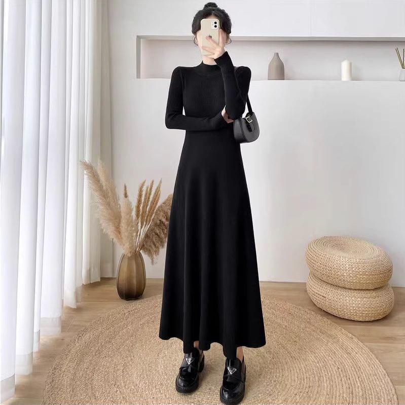Robe midi en maille noire à manches longues, encolure haute et texture côtelée, dans un design élégant idéal pour les occasions formelles