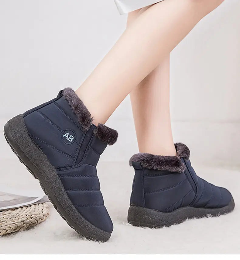 Bottines d’hiver imperméables matelassées bleu foncé, avec doublure intérieure moelleuse en fausse fourrure grise et semelle en caoutchouc noir.