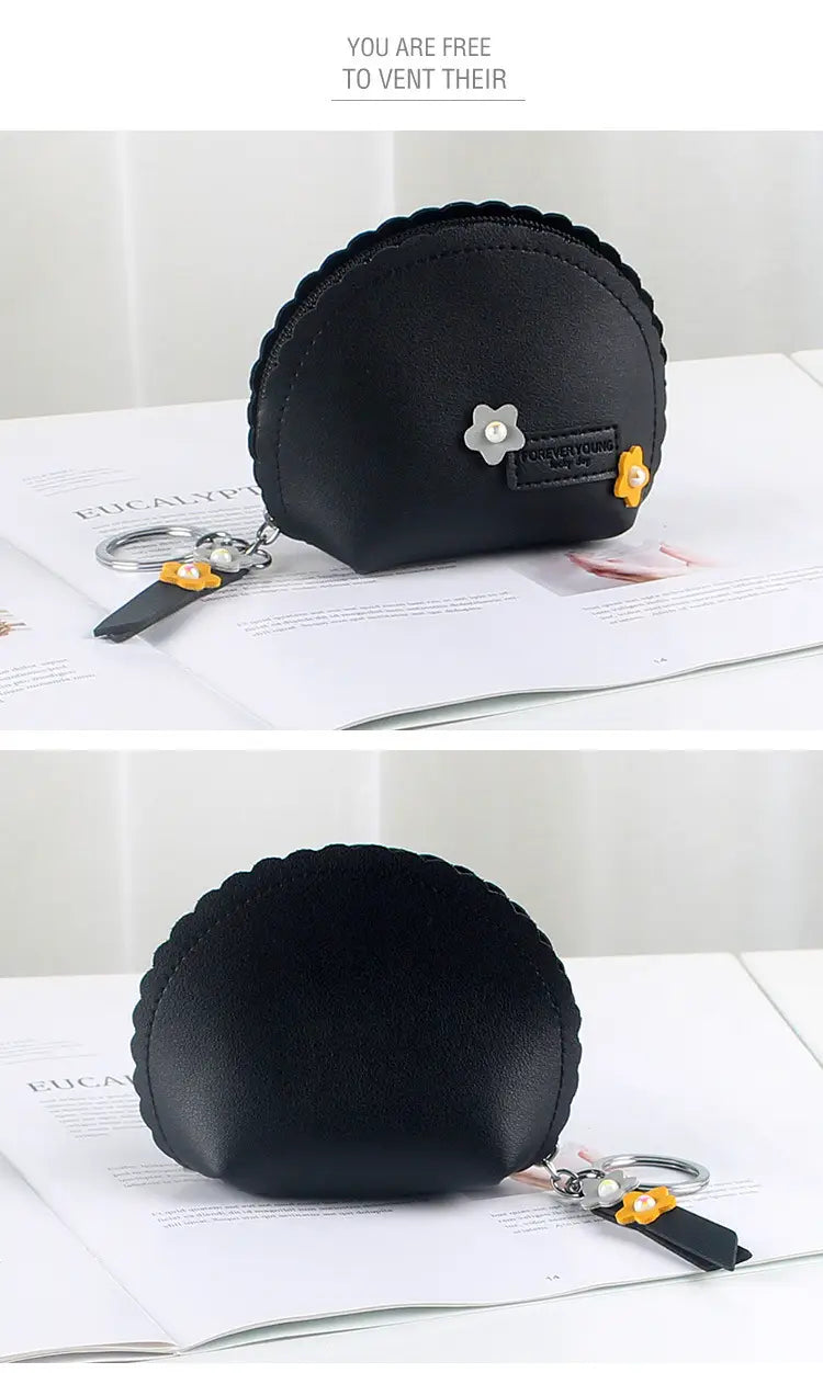 Black faux leather coin purse with scalloped edge, silver flower charm, and yellow fabric flowers for keychain use.