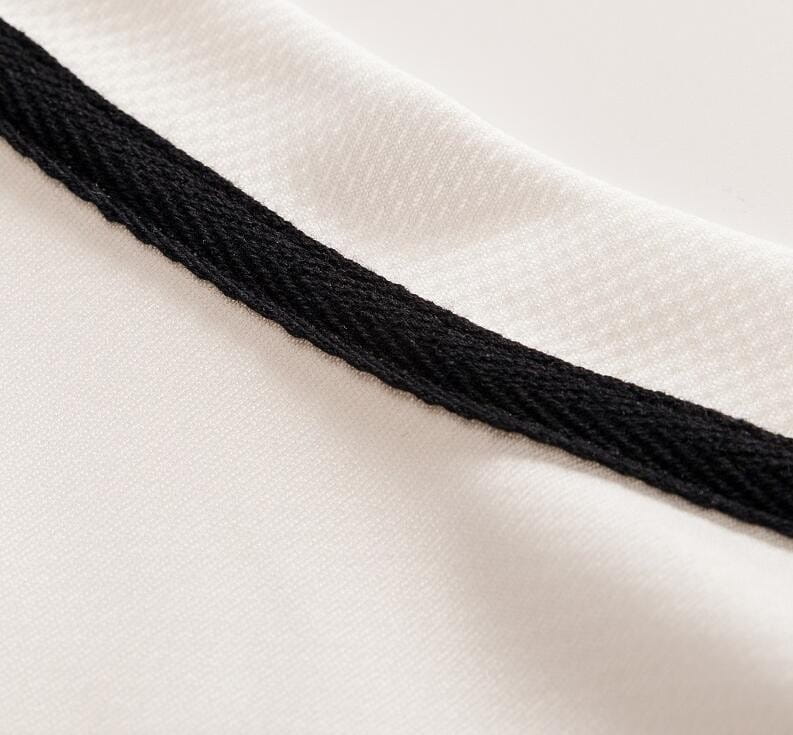 Herren-Geometric-Shortsleeve-Hemd mit Knopfleiste mit weißem, sportlichem Stoff und schwarzen, gerippten Strickbesätzen mit Akzenten am Halsausschnitt.
