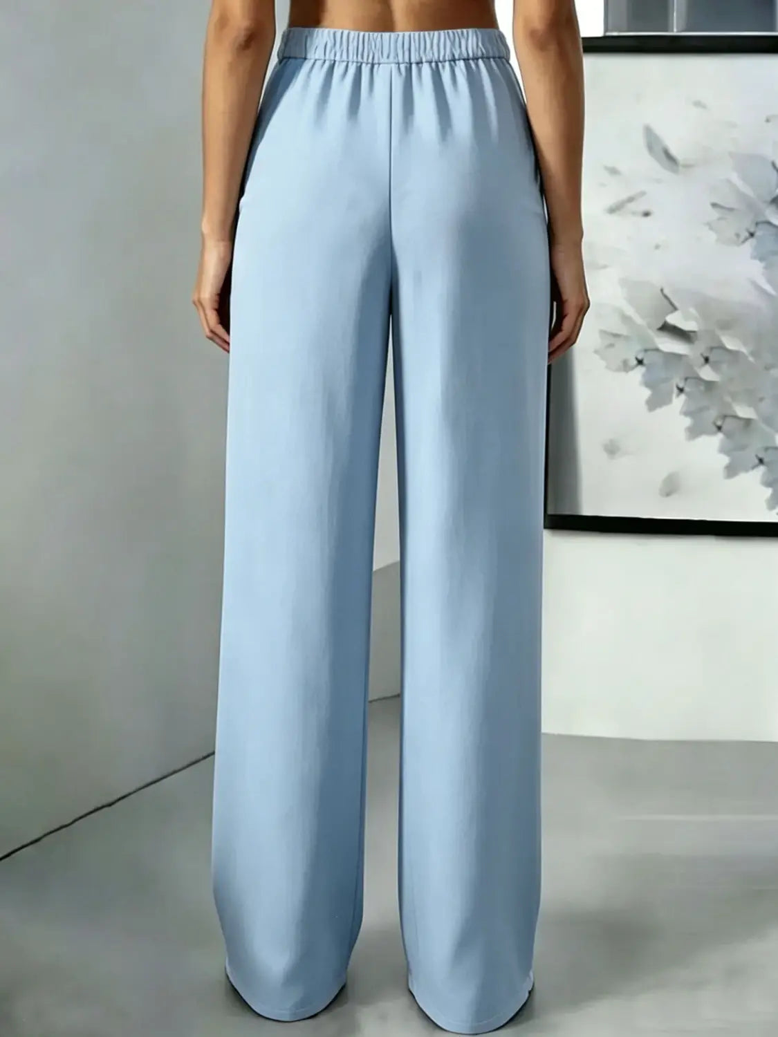 Pantalons bleu clair à jambes larges avec une ceinture élastique et un design plissé à taille haute.