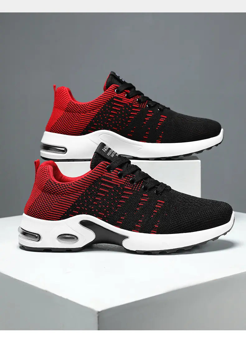 Baskets décontractées pour hommes en mesh flyknit à coussin d’air, en noir et rouge, en tricot, avec des semelles intermédiaires blanches comportant des unités d’amorti par coussin d’air visibles.