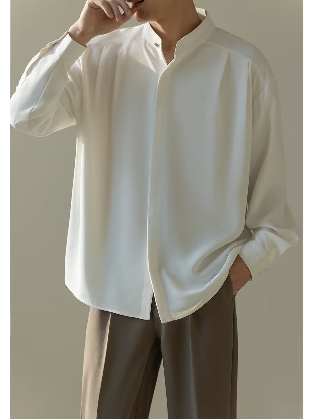 Chemise plissée pour homme à col montant en blanc éclatant, à manches longues, col mandarin et plis discrets sur l’avant.