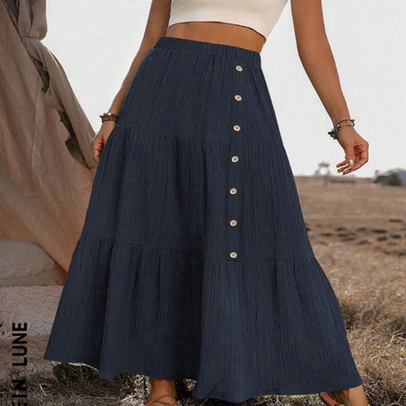 A navy blue tiered maxi skirt with pleated texture cream-colored buttons down the front made of lightweight fabric for casual wear.