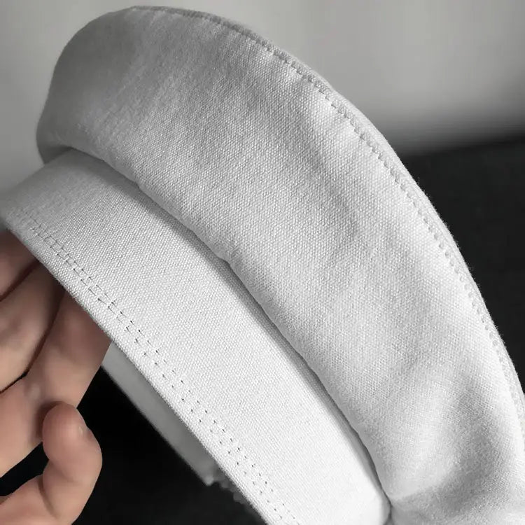 Casquette en coton blanc souple, avec une bordure légèrement courbée et structurée, et une couture soignée le long des bords, pour le béret noir en laine pour peintre pour femmes.