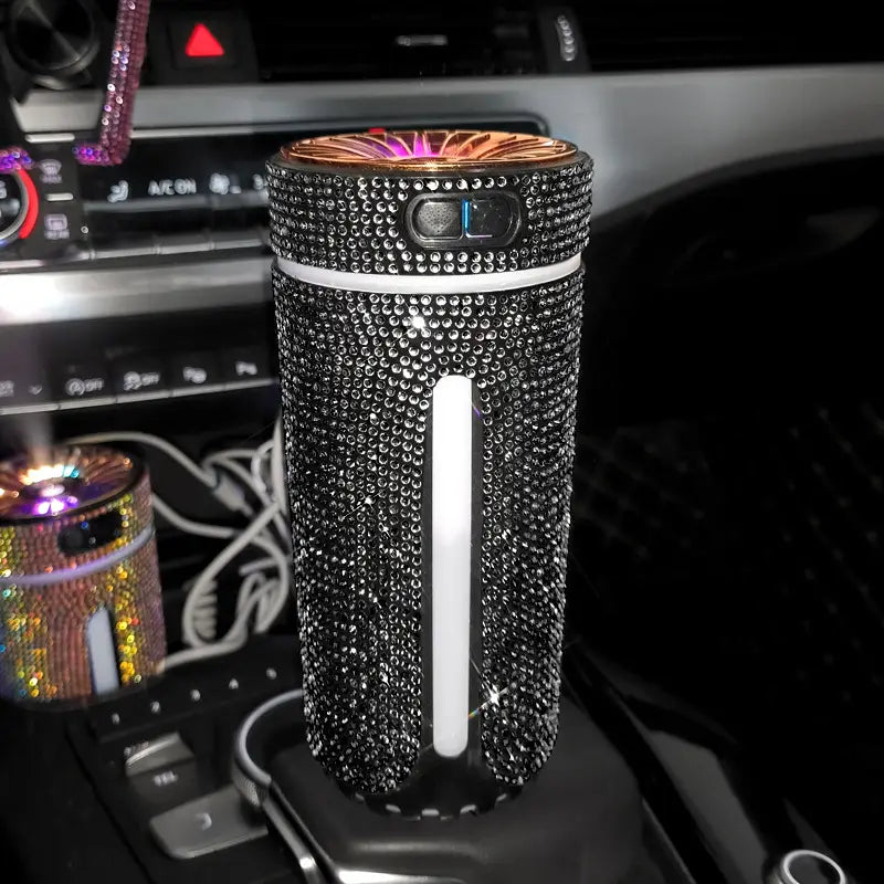 Ein mit schwarzen Strasssteinen verzierter Auto-Befeuchter mit Roségold-Oberseite und weißem vertikalem Streifen für USB-Luftdiffusor und LED-Duftverstärkung.
