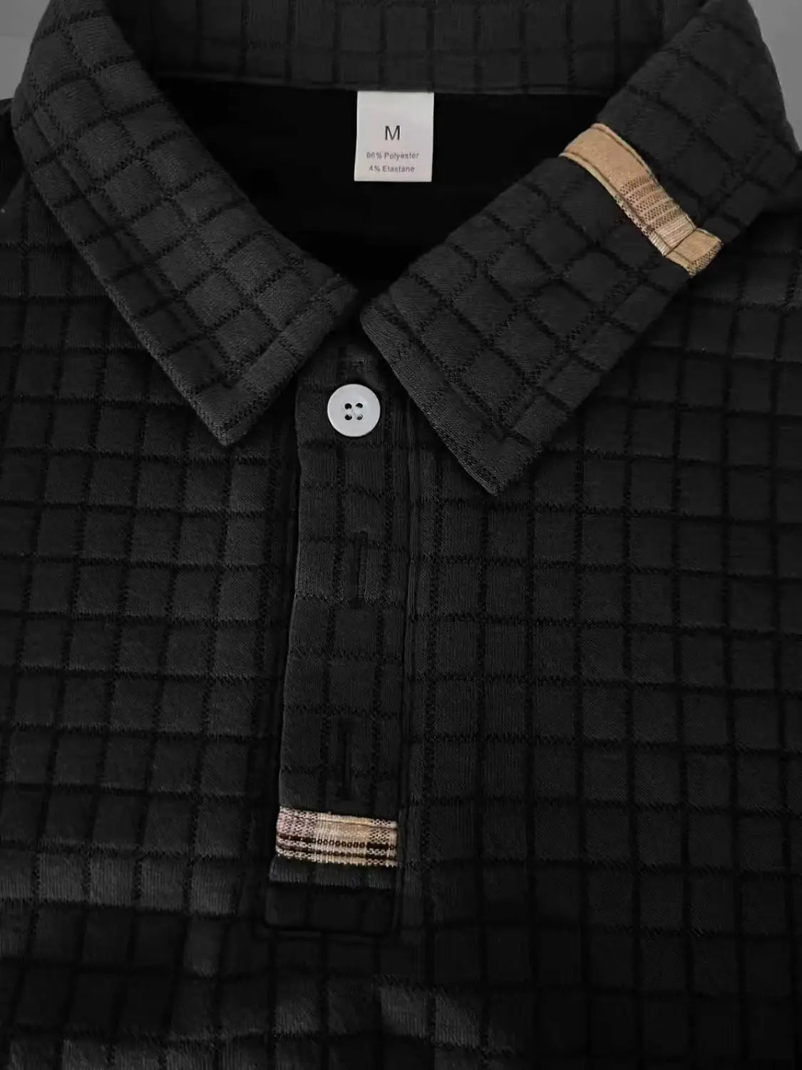 schwarzes, wattiertes Baumwoll-Poloshirt mit langen Ärmeln im karierten Stil für Herren mit dezentem Karomusterbesatz am Kragen und an den Bündchen, ausgelegt für sportliche und legere Nutzung.
