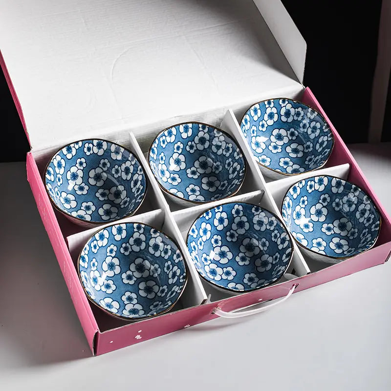 Set of six blue and white floral ceramic bowls with gold rims made of porcelain neatly arranged in a pink gift box measuring five inches.