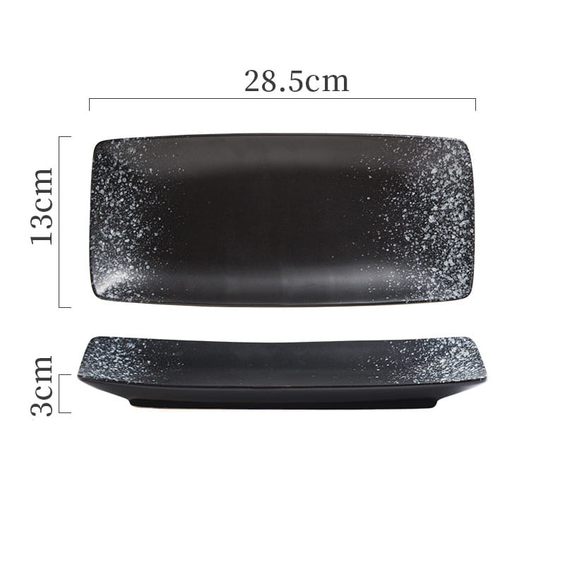 Black rectangular ceramic sushi plate with speckled white glaze along the edges ideal for Japanese cuisine serving.