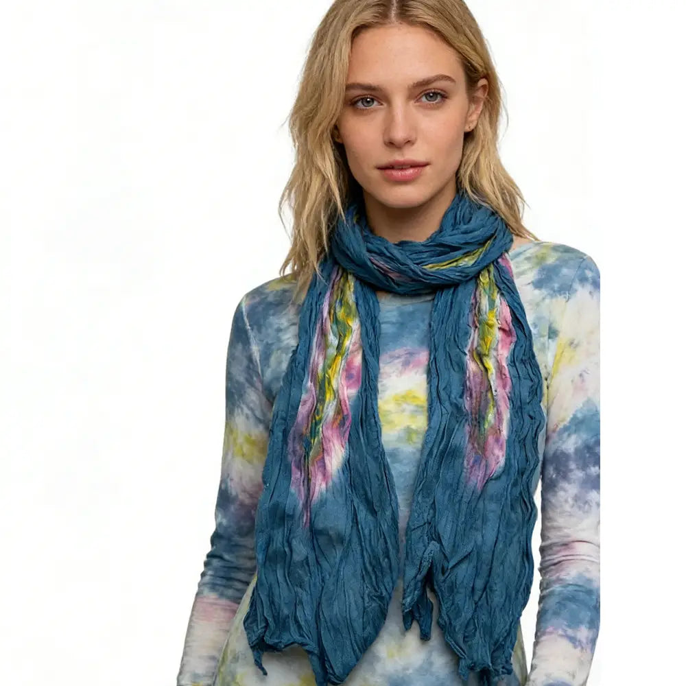 Ein gemustertes Türkis-Tie-Dye-Baumwoll-Crinkle-Schal mit kräftigen Akzenten in Pink und Gelb, das locker um den Hals drapiert ist.