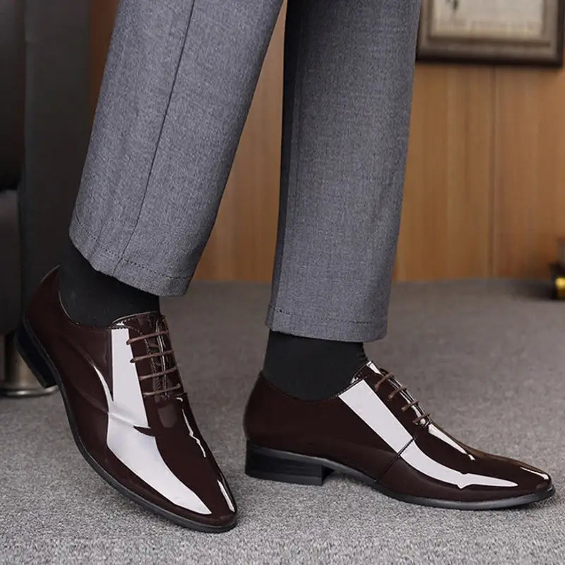 Men’s classic pointed toe leather business shoe in black patent leather with a glossy finish and white toe panel.