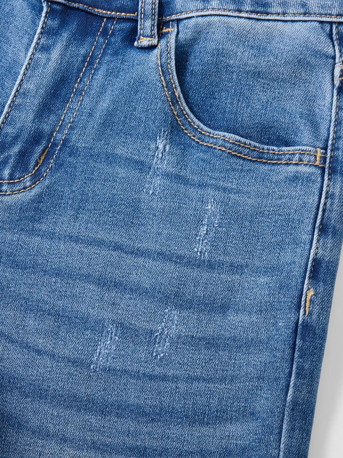 Wide leg stretch denim jeans in medium-wash blue with subtle distressing and contrasting stitching made from comfortable denim material.