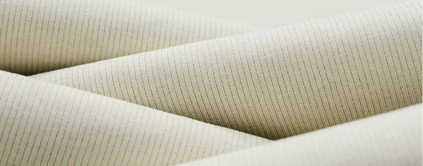 Pantalon pour hommes à plis, coupe ample à jambes larges et ajustement décontracté, en tissu tricot côtelé beige, avec des rayures verticales discrètes.