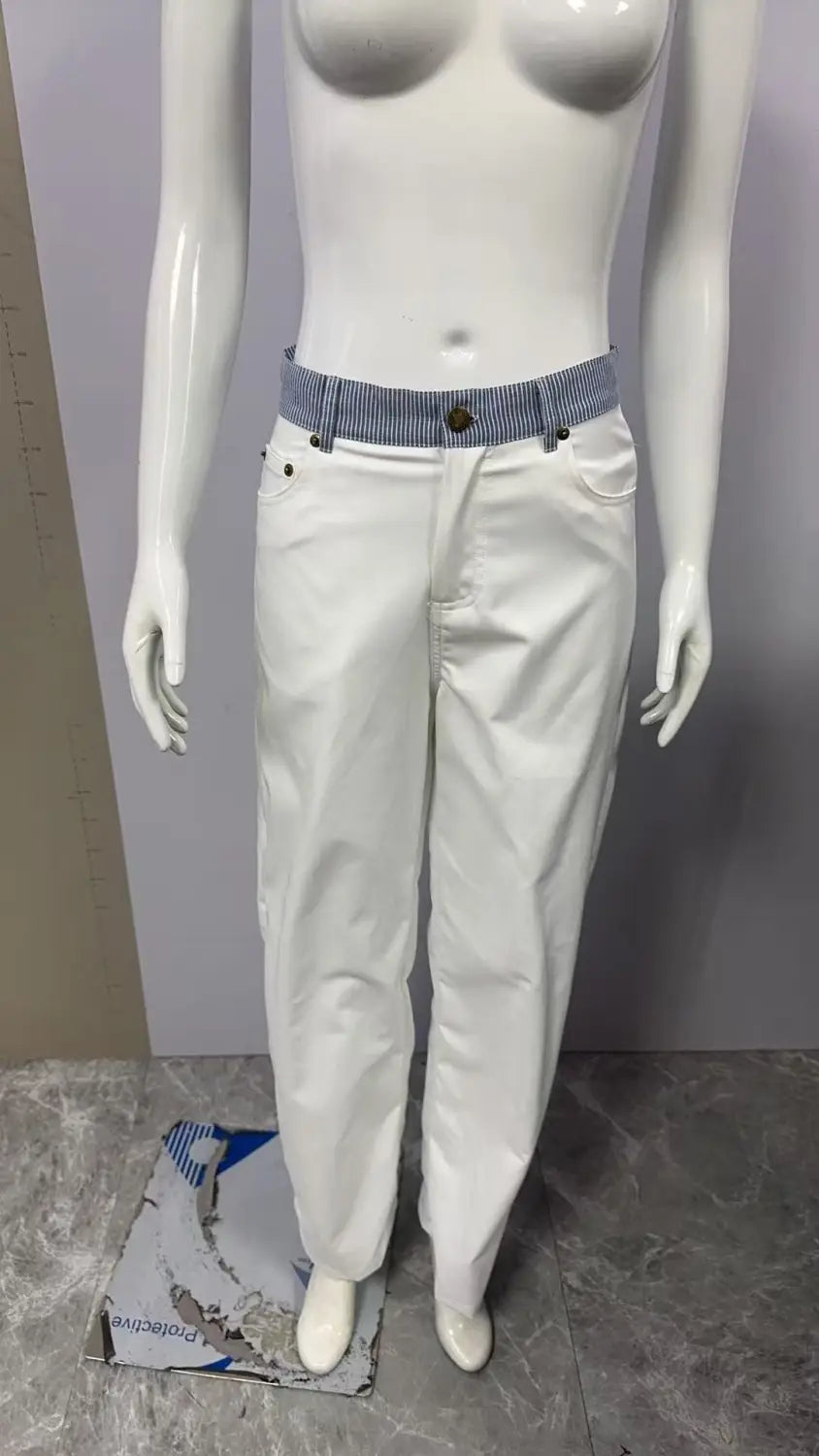 Jean en denim blanc à jambes évasées avec une ceinture rayée, comprenant une bande rayée blanche à la taille.