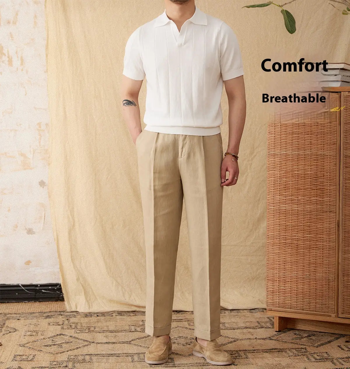 A man wearing a white men knit stripe polo shirt with vertical pleats and beige trousers.