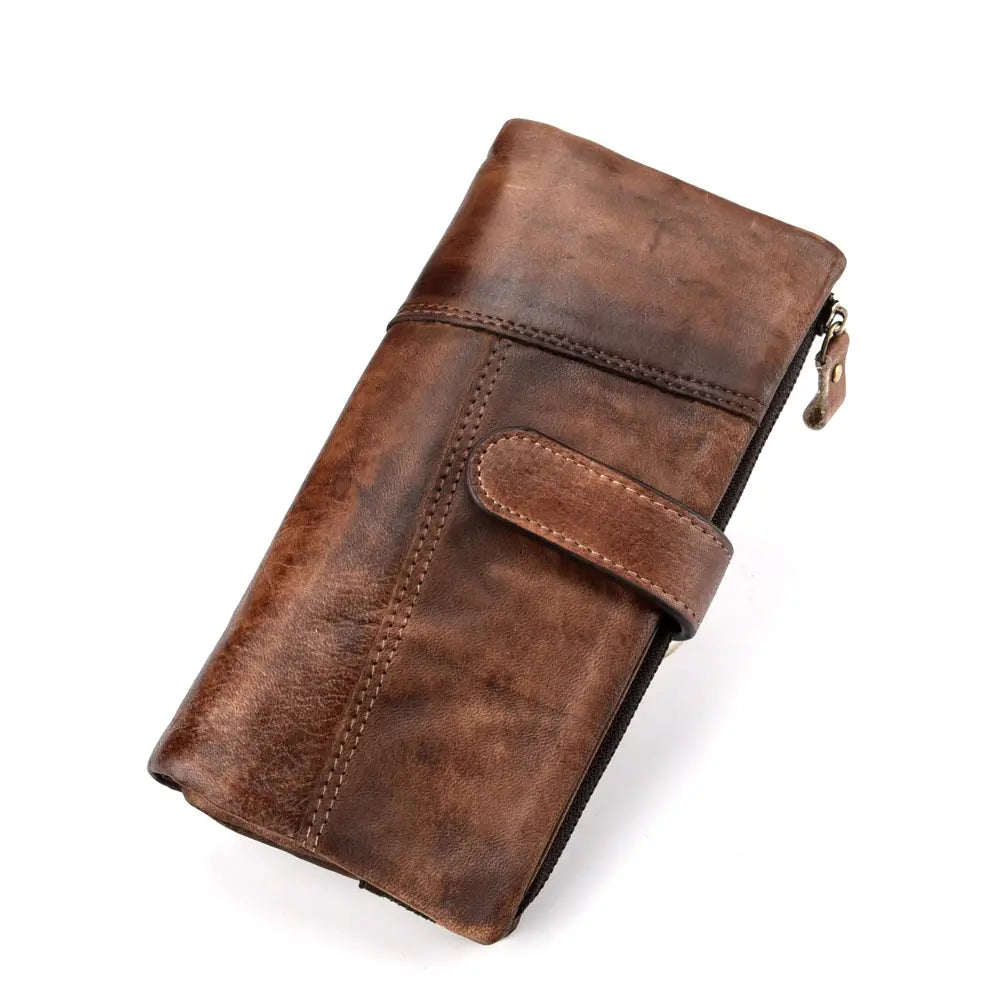 A distressed brown leather long wallet with vintage stitching and a zipper closure.