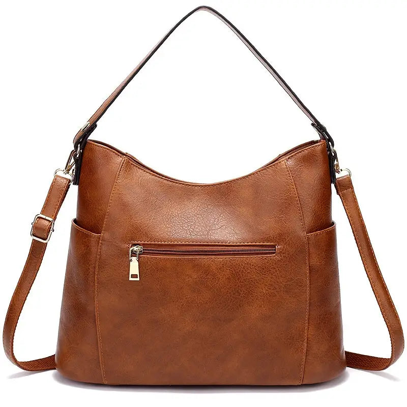 Brown faux leather hobo bag with tassel and front zipper pockets featuring a single shoulder strap and adjustable crossbody strap.