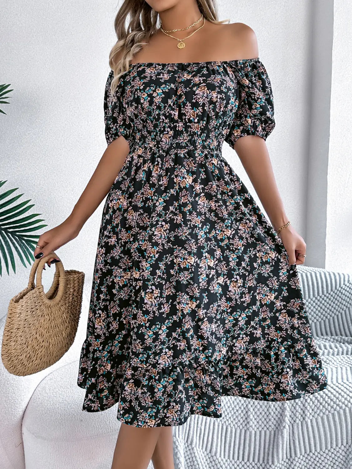 Robe noire décolletée décolleté avec manches bouffantes et jupe évasée, encolure carrée et détails à volants, idéale pour l’été