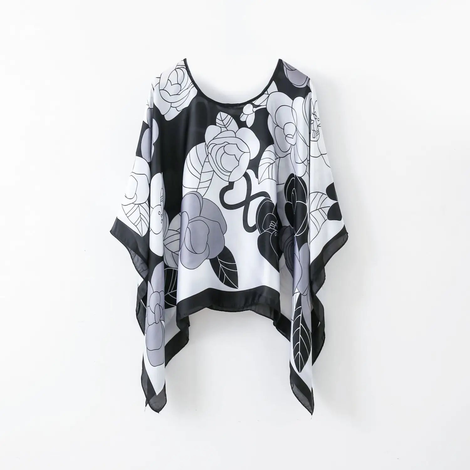 printed silk patterned pullover shawl cape outerwear featuring a flowing black white and gray floral print with a round neckline made of silk.