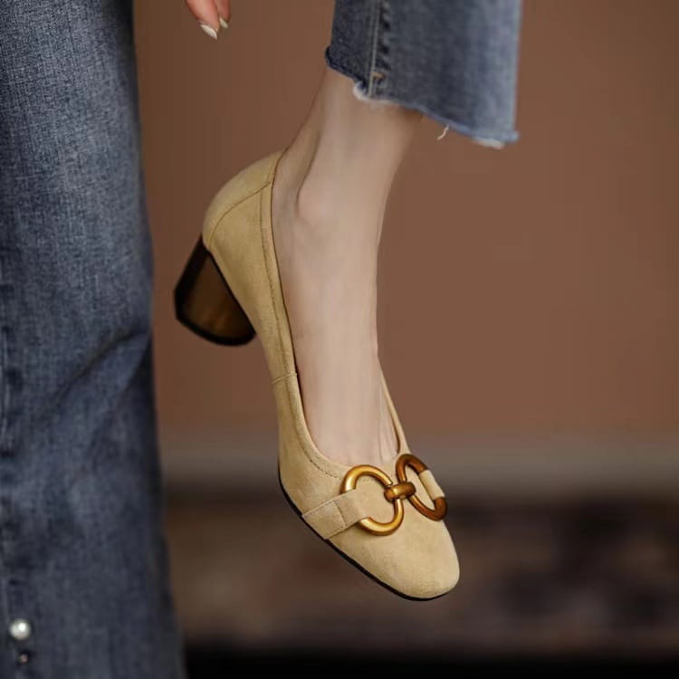 Beige suede square toe leather pump featuring a gold-toned double-ring buckle and a low block heel.