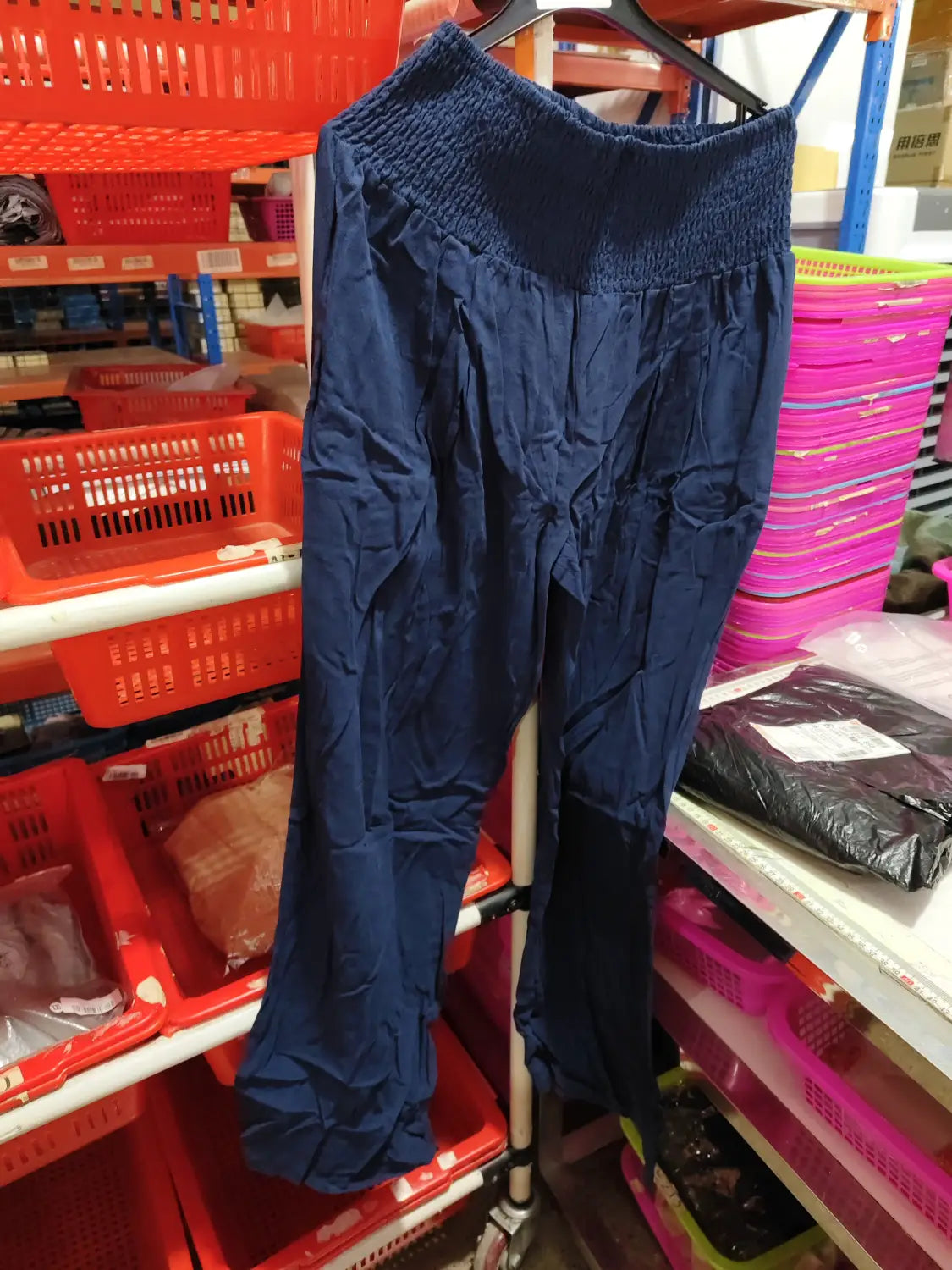 Navy blue smocked wide leg pants for women with a high waist, elastic waistband, relaxed fit, and subtle pleats along the legs.