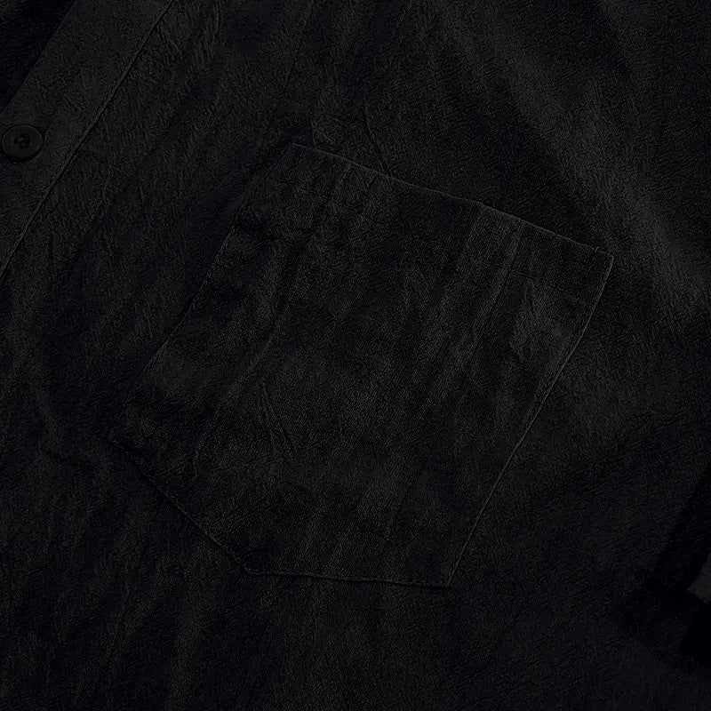 Herren-Leinenhemd mit kurzen Ärmeln in schwarzem, strukturiertem Stoff mit dezentem Webmuster und einer einzelnen Brusttasche für ein legeres Button-down.