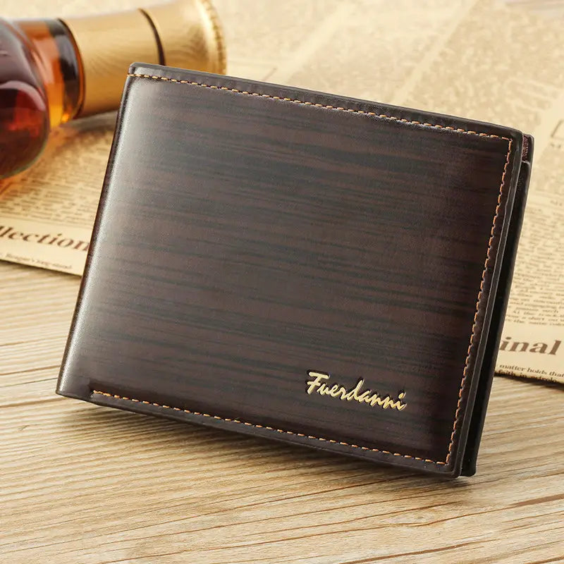 Dark brown leather men’s bifold wallet with card slots id window gold stitching subtle wood grain texture and fuerdanni brand name embossed in gold lettering.