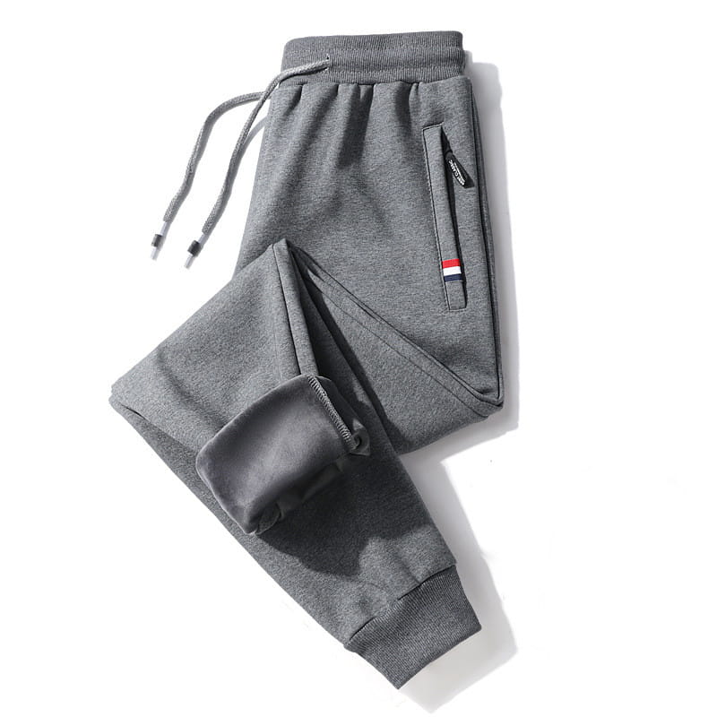 Men fleece lined joggers in gray cotton with a drawstring waistband, ribbed cuffs and ankles, and a side pocket with a red white blue stripe detail.
