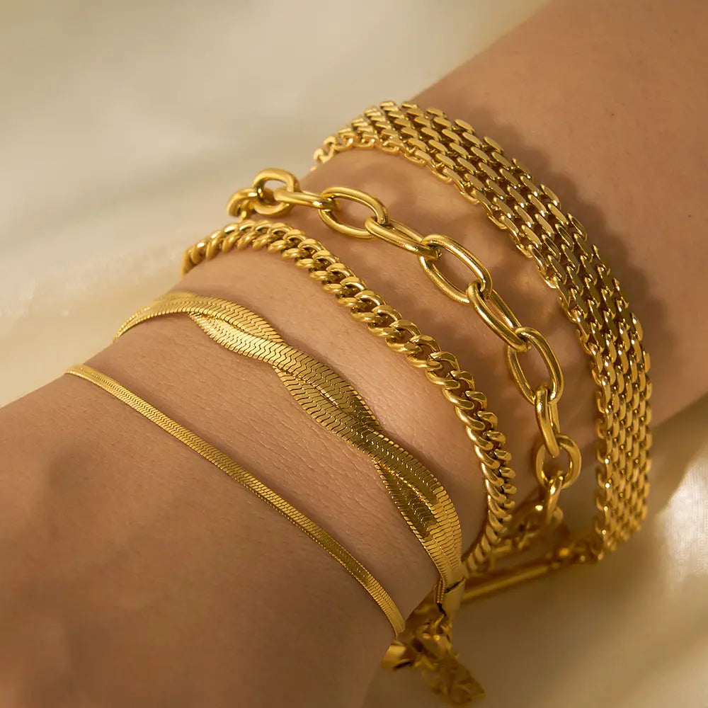 A set of five 18k gold PVD plated stainless steel chain link bracelets featuring varying styles including wide mesh and delicate snake link designs.