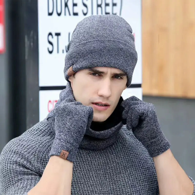 Gray knit winter hat with ribbed brim and matching touchscreen gloves featuring a small brown leather patch on the wrist.