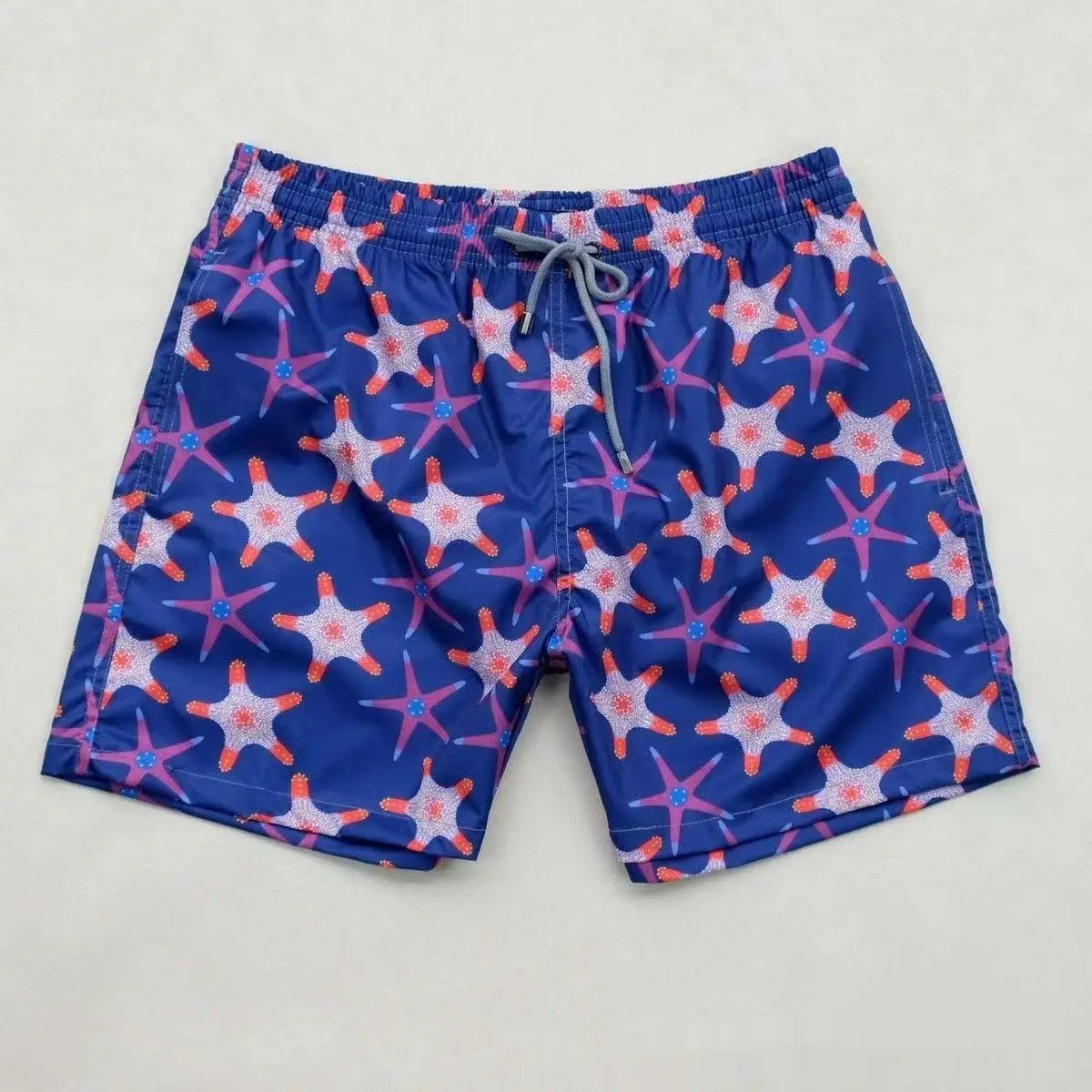 blue turtle quick drying beach pants swim trunks featuring a vibrant pattern of pink and white starfish with orange accents and gray drawstrings.