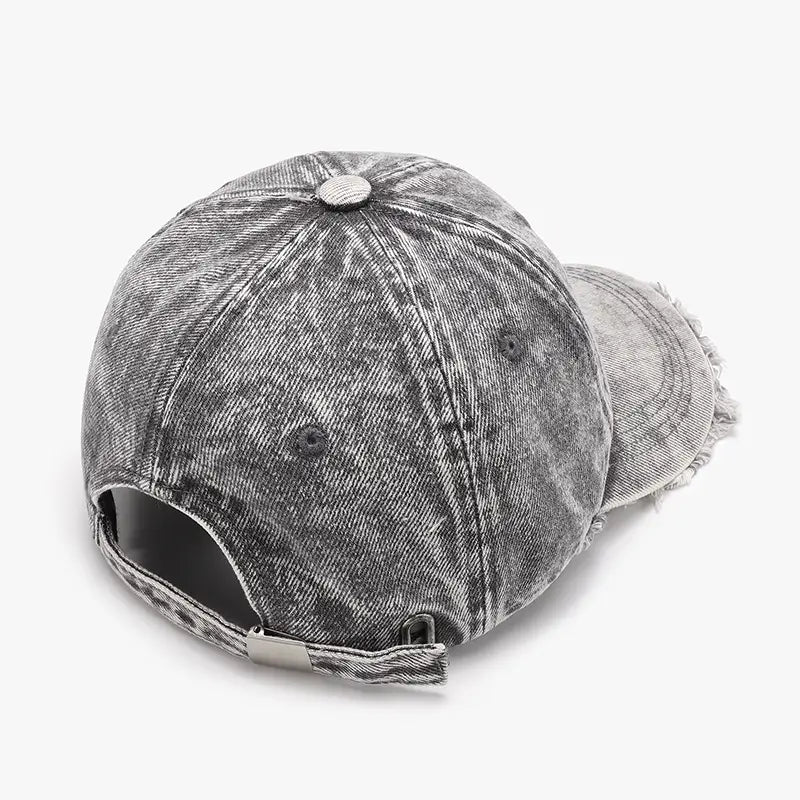A distressed gray denim baseball cap with a frayed brim and adjustable strap shown from the back.