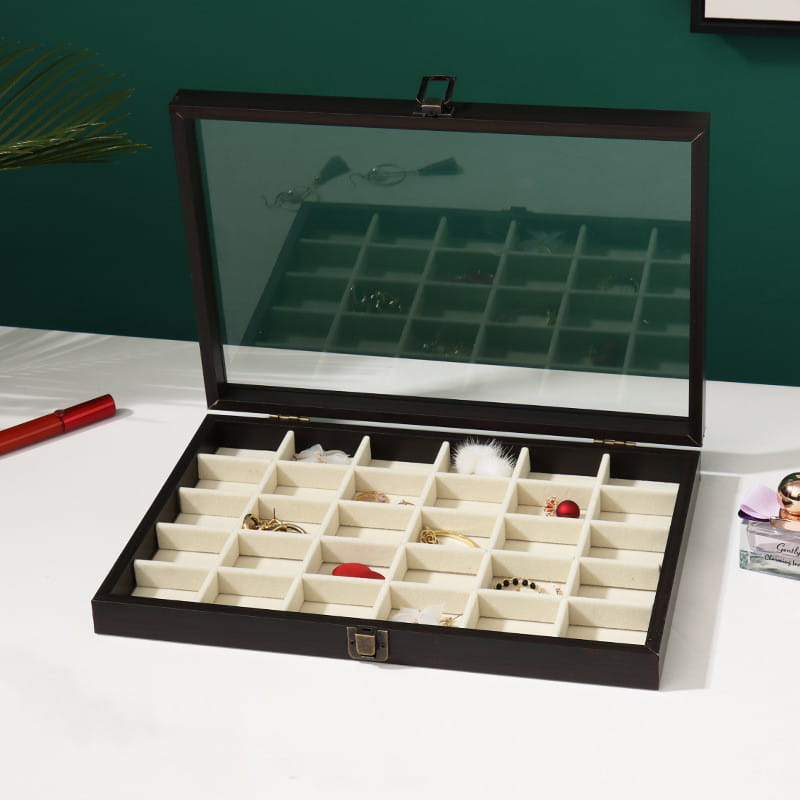 Black wooden rosewood jewelry display box with glass lid and cream-colored velvet compartments for organizing jewelry.