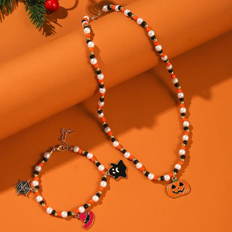 Halloween ghost and pumpkin beaded jewelry set featuring an orange black and white beaded halloween-themed necklace with a pumpkin charm.