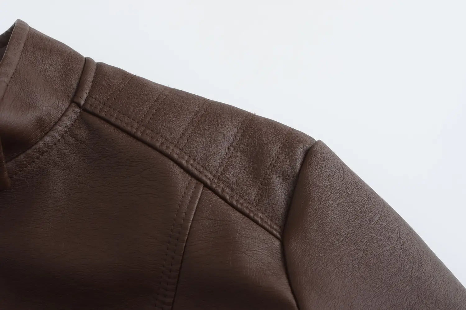 Veste motard en faux cuir marron avec col montant, présentant des panneaux d’épaules matelassés et une couture précise