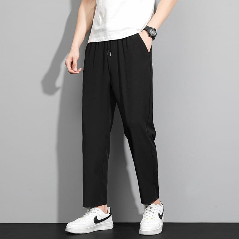 Schwarze, schmal geschnittene Baumwoll-Herren-Freizeithose mit Kordelzug, mit Kordelzugbund und dezenten Seitennähte-Details.