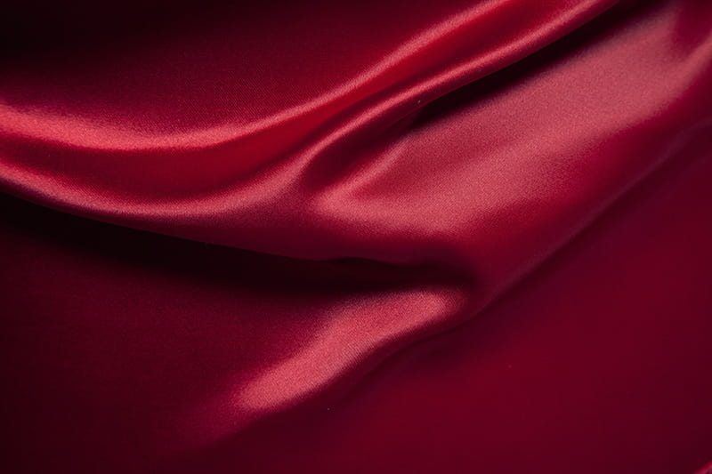 Camisa de manga larga colorblock de satén rojo intenso, confeccionada en tejido liso y brillante, con pliegues que caen con fluidez.
