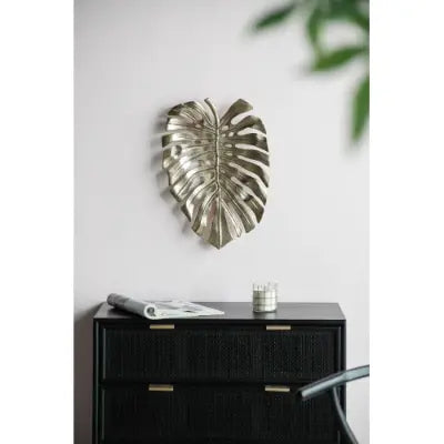 Silver monstera leaf wall art with a metallic textured finish featured as gold monstera leaf wall decor and serving tray.