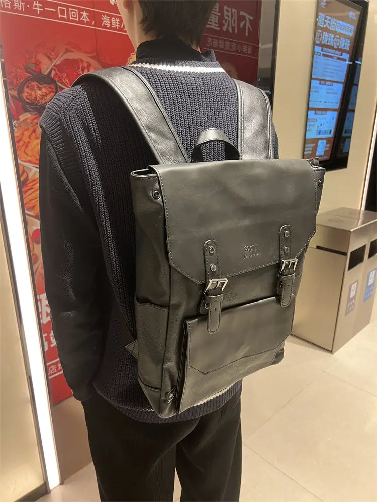 Dark gray leather vintage college backpack with silver-toned metal buckles and front flap closure designed for large capacity travel use.