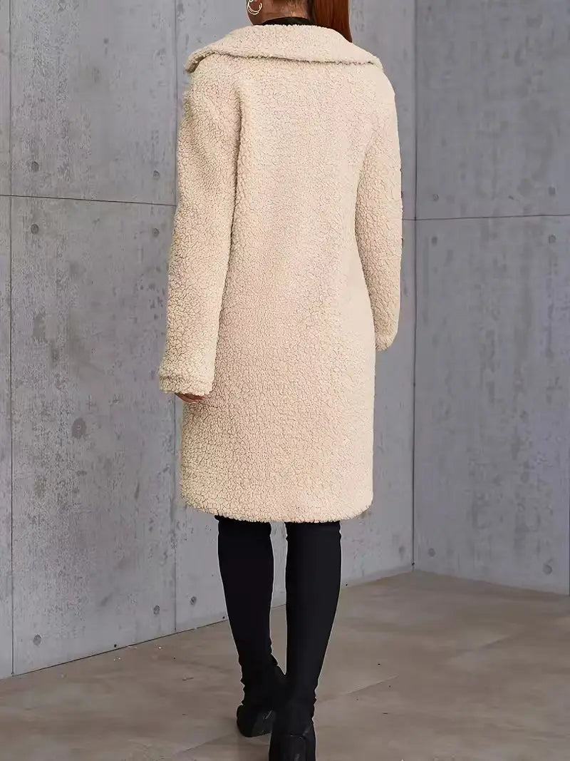 Manteau teddy mi-long doublé en polaire de couleur crème, avec une surface moelleuse texturée et un col classique.