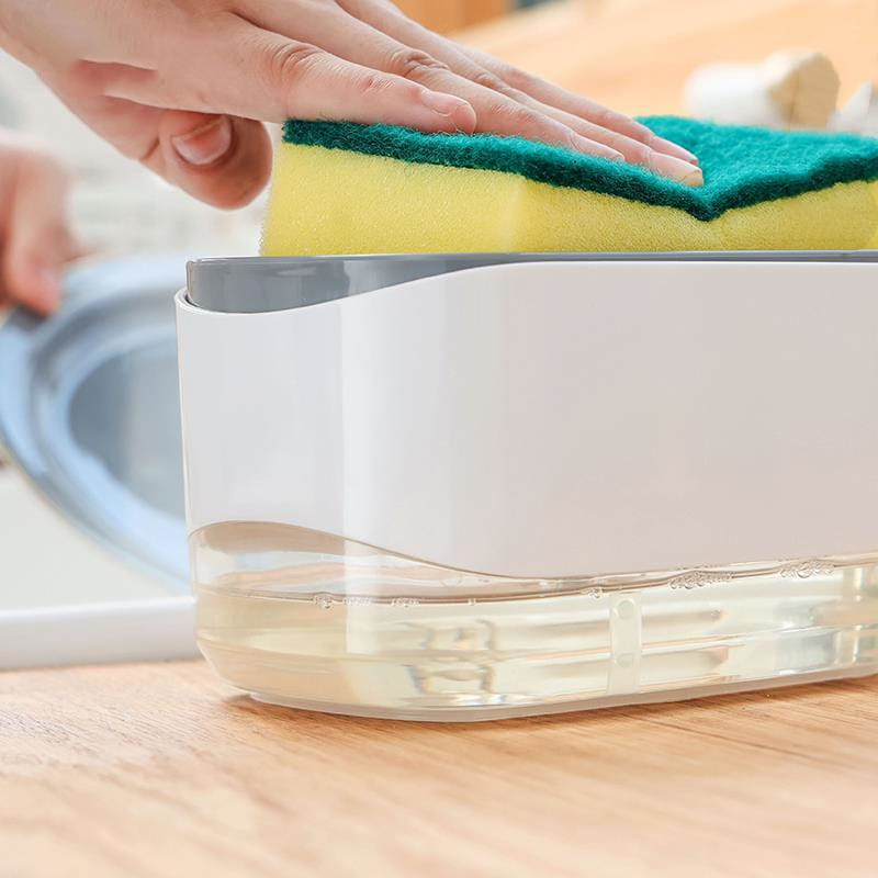 Dispensador de jabón líquido para platos de plástico blanco y transparente con tapa gris y soporte para esponja integrado, que contiene una esponja de limpieza amarilla y verde de capacidad de 350 ml