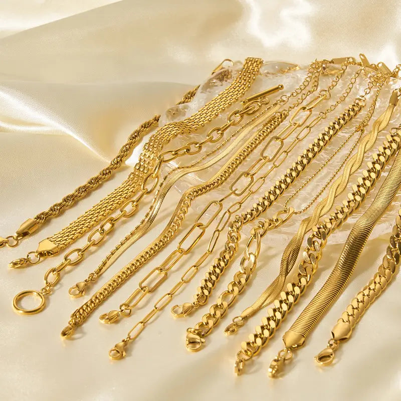 A collection of 18k gold pvd plated stainless steel chain link bracelets featuring various styles including snake box and curb links.