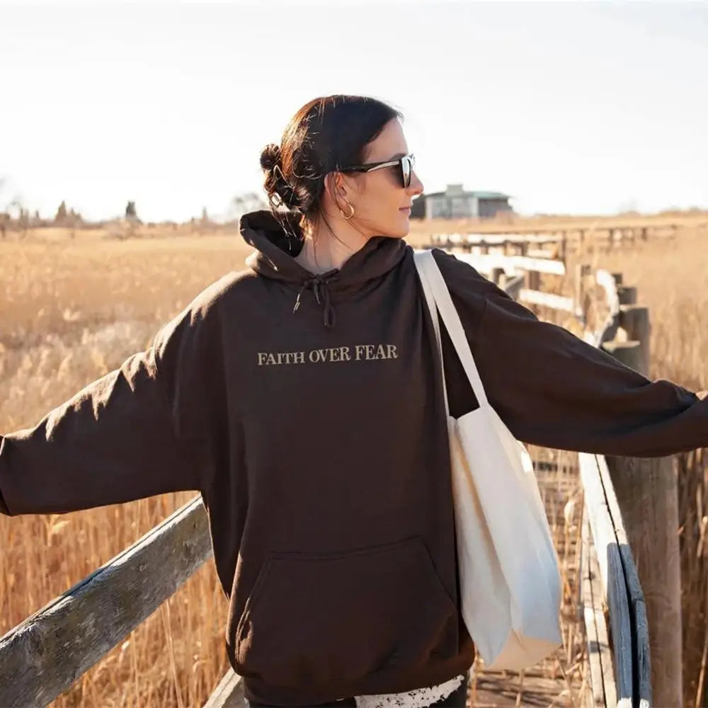 Black hoodie made of soft material featuring faith over fear Psalm 118 6 printed in white across the chest, ideal for Christian aesthetic wear.
