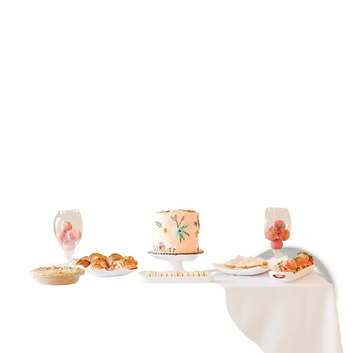 Pastel peach and white 1st birthday photo banner with delicate floral cake icing displayed on a tiered stand