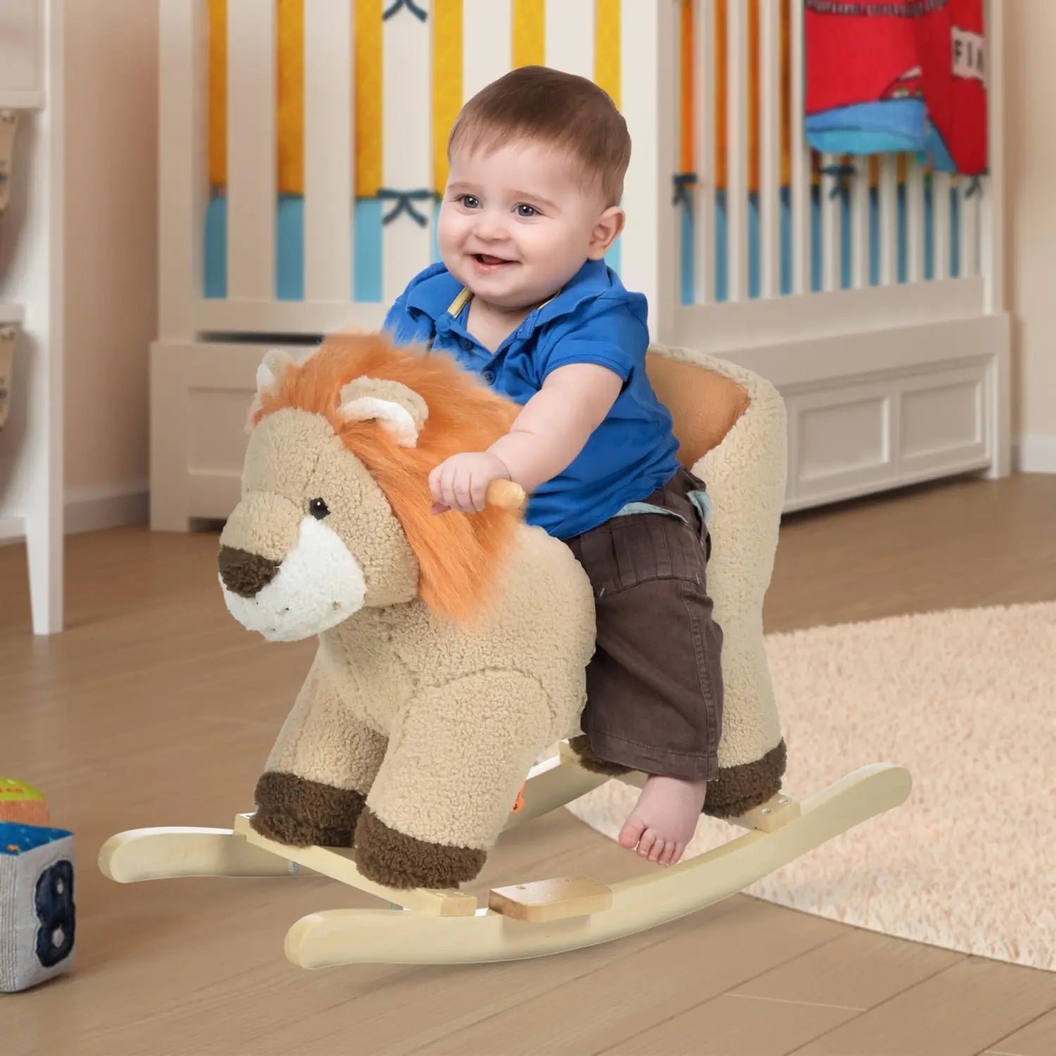 Cheval à bascule en peluche en forme de lion avec fonction sonore et harnais de sécurité, fourrure beige et orange, pattes brunes, nez brun et base en bois pour le basculement.