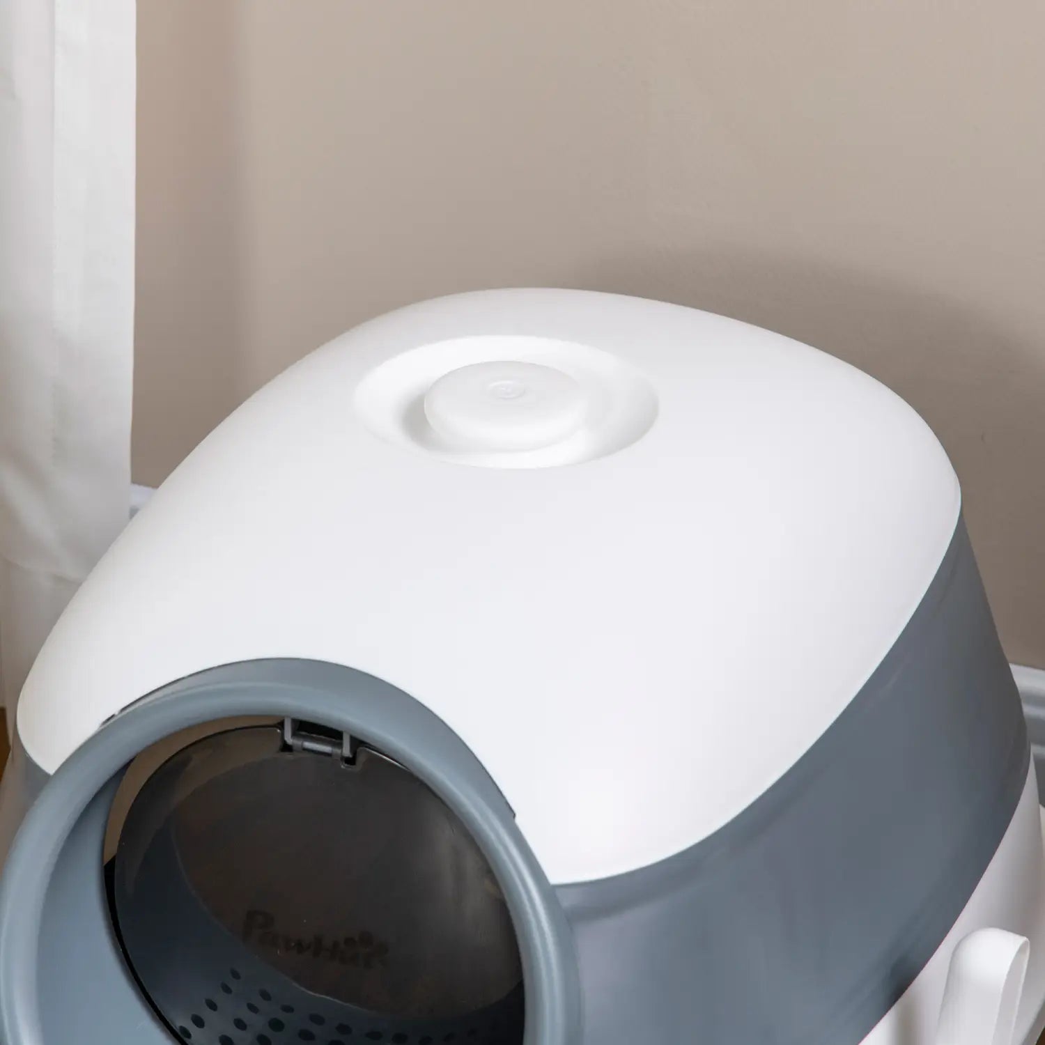 Caja para arena de gato con cubierta tipo cúpula de plástico en blanco y gris, con función de autolimpieza y un diseño moderno de líneas redondeadas.