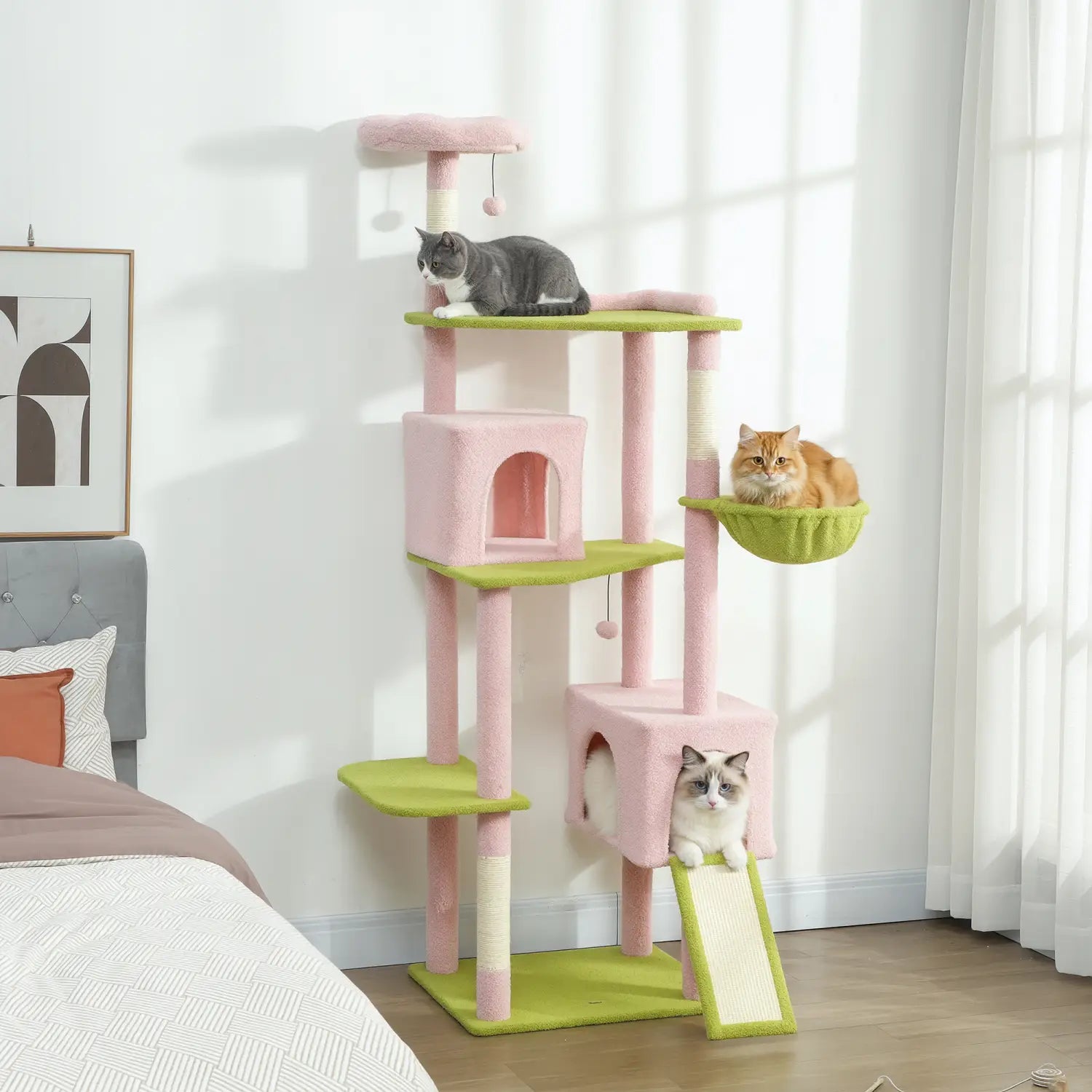 Pink floral multi-level cat tree tower with soft carpeted pink and green platforms, scratching posts, and a hammock-style perch for cats.