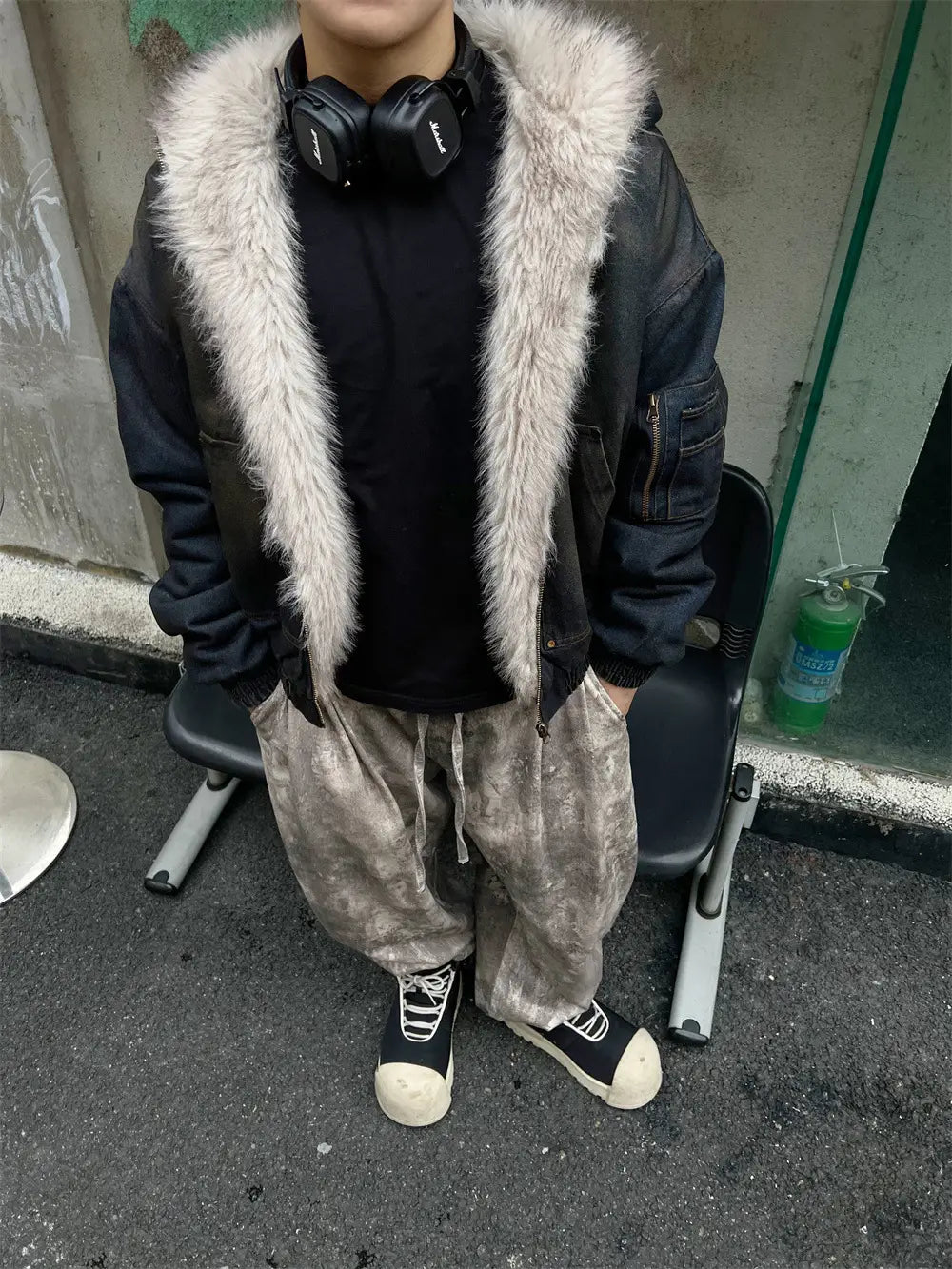 男性用ダメージ加工デニムフード付きウィンタージャケットの一部として用いられた、淡いライトグレーのフェイクファー襟付きブラックボンバージャケット。