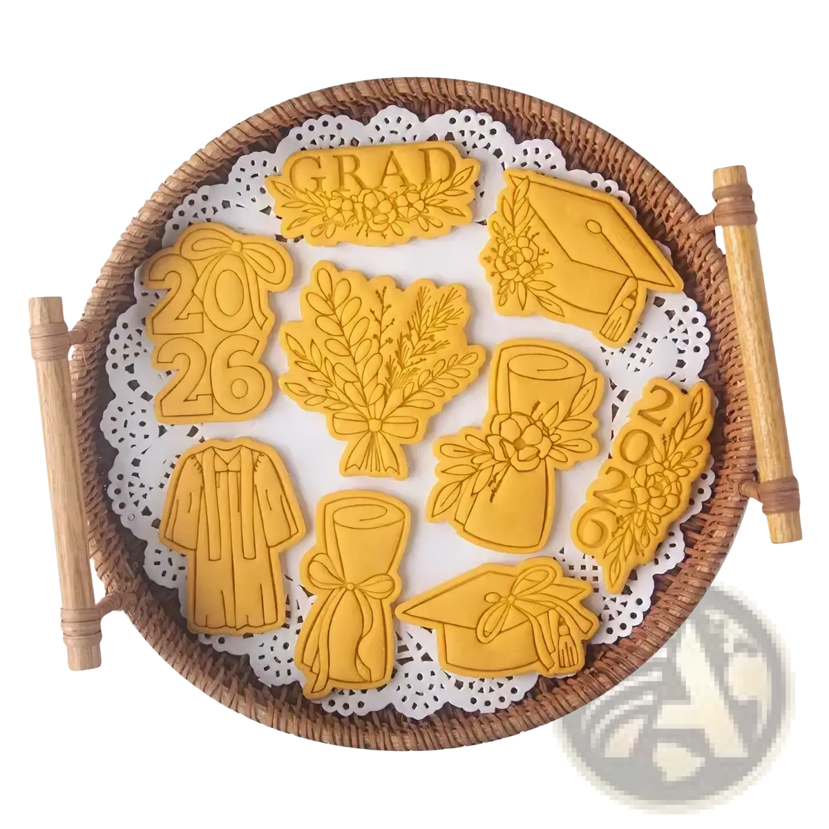 Golden metal 2026 graduation cookie cutter set arranged on a woven tray for celebration baking purposes